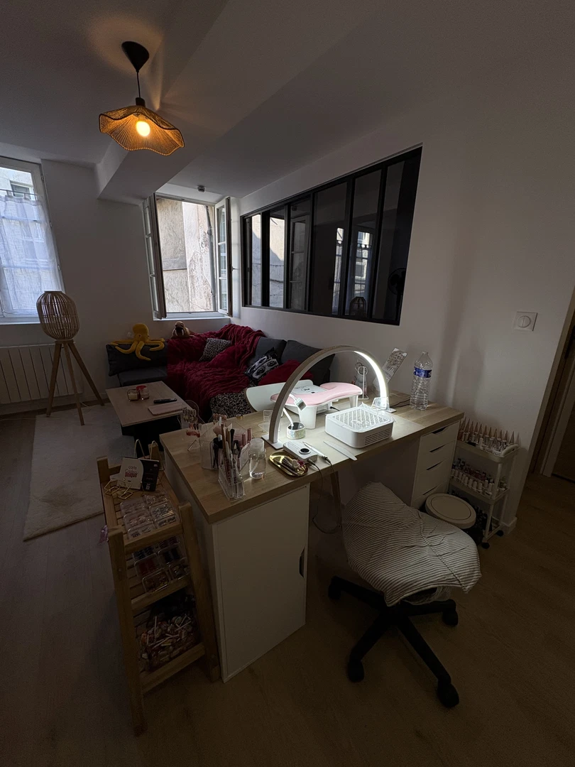 Le studio privé de nailssmarion à Rouen : canapé, plaid bordeaux et poste de pose